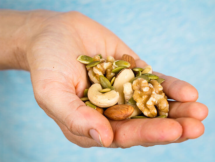 A close-up shot of a handful of mixed nuts and seeds, showcasing their natural beauty and health benefits.