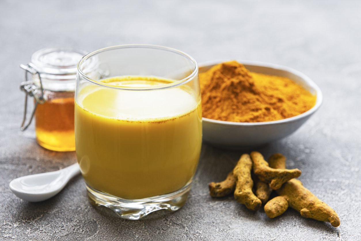 A golden-hued cup of turmeric tea, steam rising, symbolizing warmth, healing, and comfort.