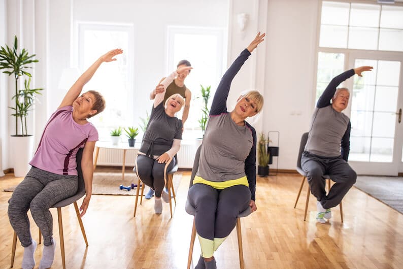 Seniors doing chair exercises or seated yoga